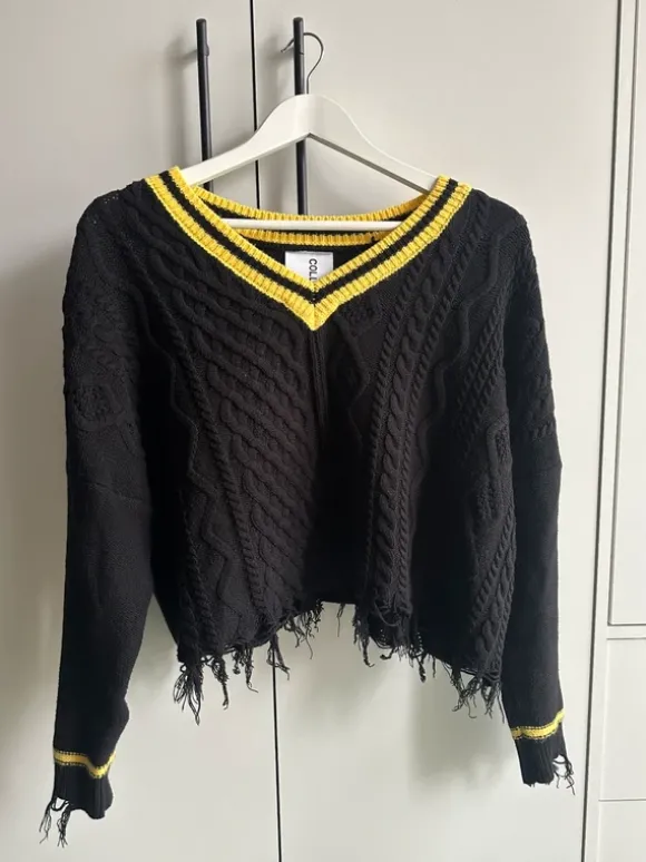 schwarzer pullover mit gelben details und fransen