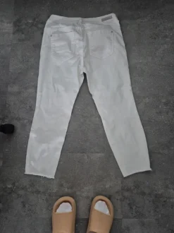 Weisse Jeans mit klassischem Schnitt, leichter Used-Optik und ausgefransten Säumen